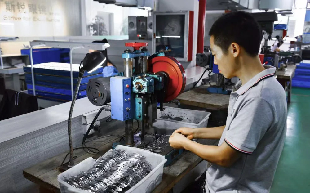An operator working with frame components at a machining station.